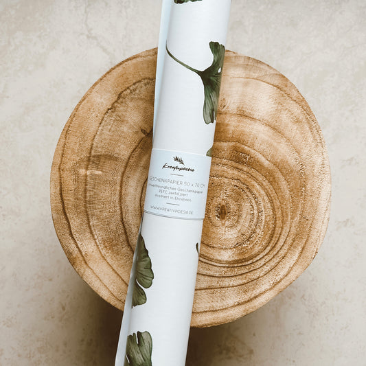 Geschenkpapier-Bogen in der Größe 50x70cm (aufgerollt). Der Hintergrund ist weiß, auf ihm befinden sich ganz viele Ginkgoblätter.