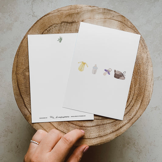 Postkarte im Hochformat. Anlass: Baby, Geburt, Zwillinge, Babyparty, Glückwunsch. Auf der Karte befinden sich vier typische Baby Gegenstände, welche alle mittig von links nach rechts angeordnet sind. Ganz links befindet sich ein gelber Babybody. Daneben eine Milchflasche mit hellblauem Verschluss. Danach kommt ein lilaner Schnuller und ganz rechts befindet sich ein brauner Schnürschuh. Die Karte bietet oben und unten genug Platz für Texte.