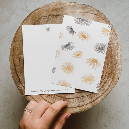 Postkarte DIN A6 im Hochformat. Vielen Gänseblümchen im Line-Art-Stil und Aquarellstil.