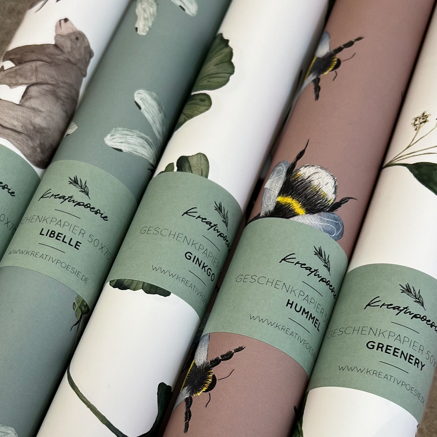 Aufgerollte Geschenkpapierbögen in 50x70cm. Übersicht verschiedener Motive.