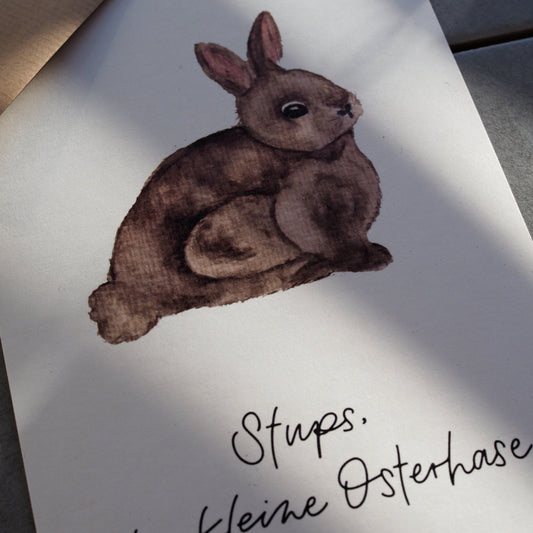 Osterpostkarte mit braunem Hasen. Text ,,Stups der kleine Osterhase''. Nahansicht.