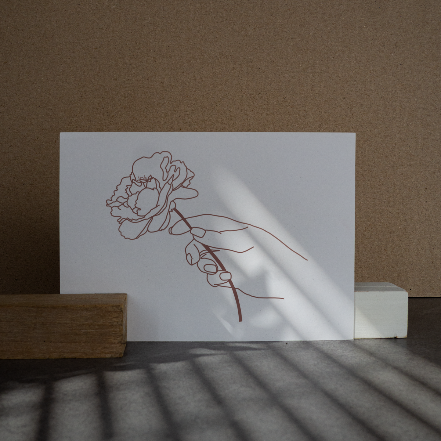 Postkarte, Lineart in rosa. Hand, die eine Pfingstrose hält. Gedruckt auf Recyclingpapier in Deutschland.
