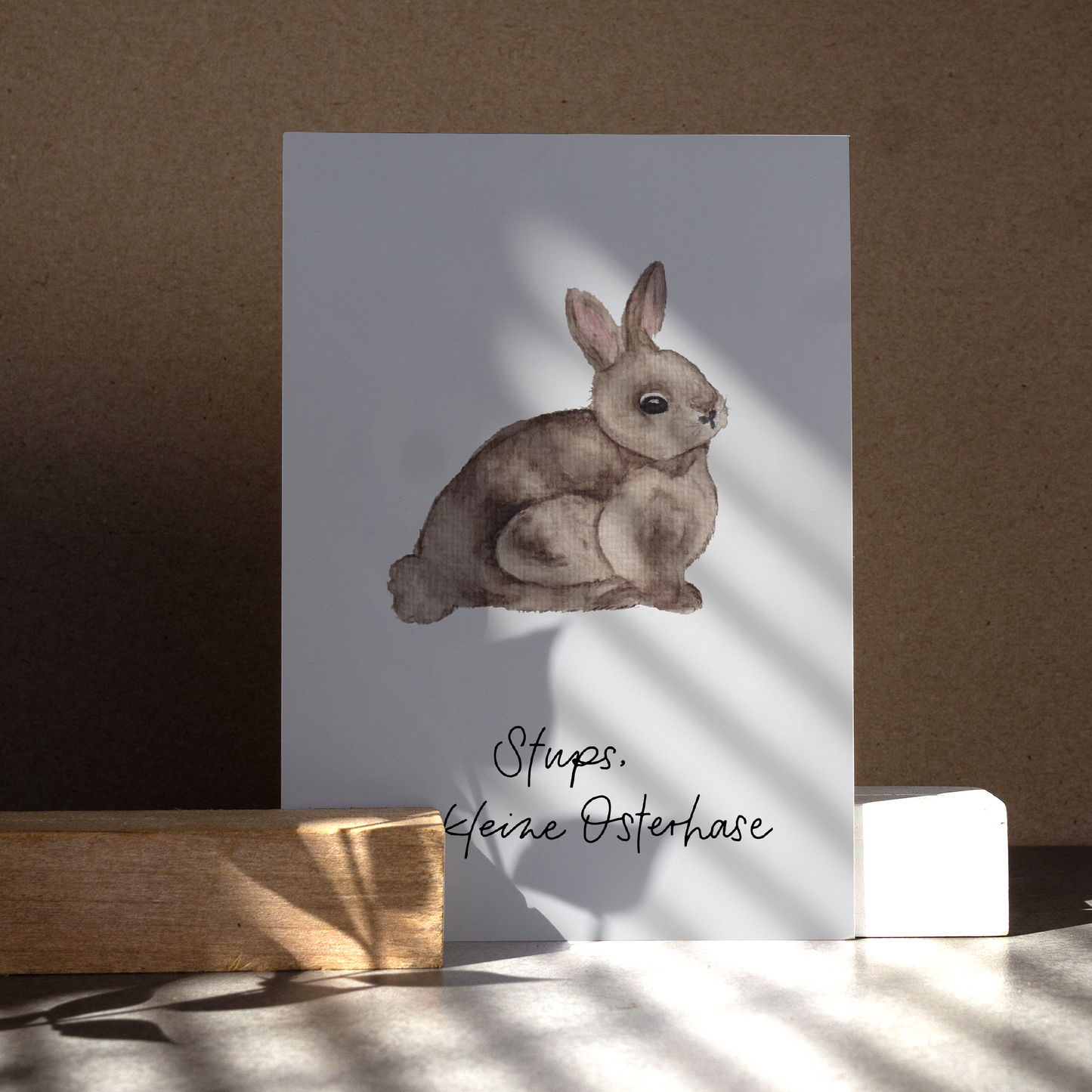 Osterpostkarte mit braunem Hasen. Text ,,Stups der kleine Osterhase''.