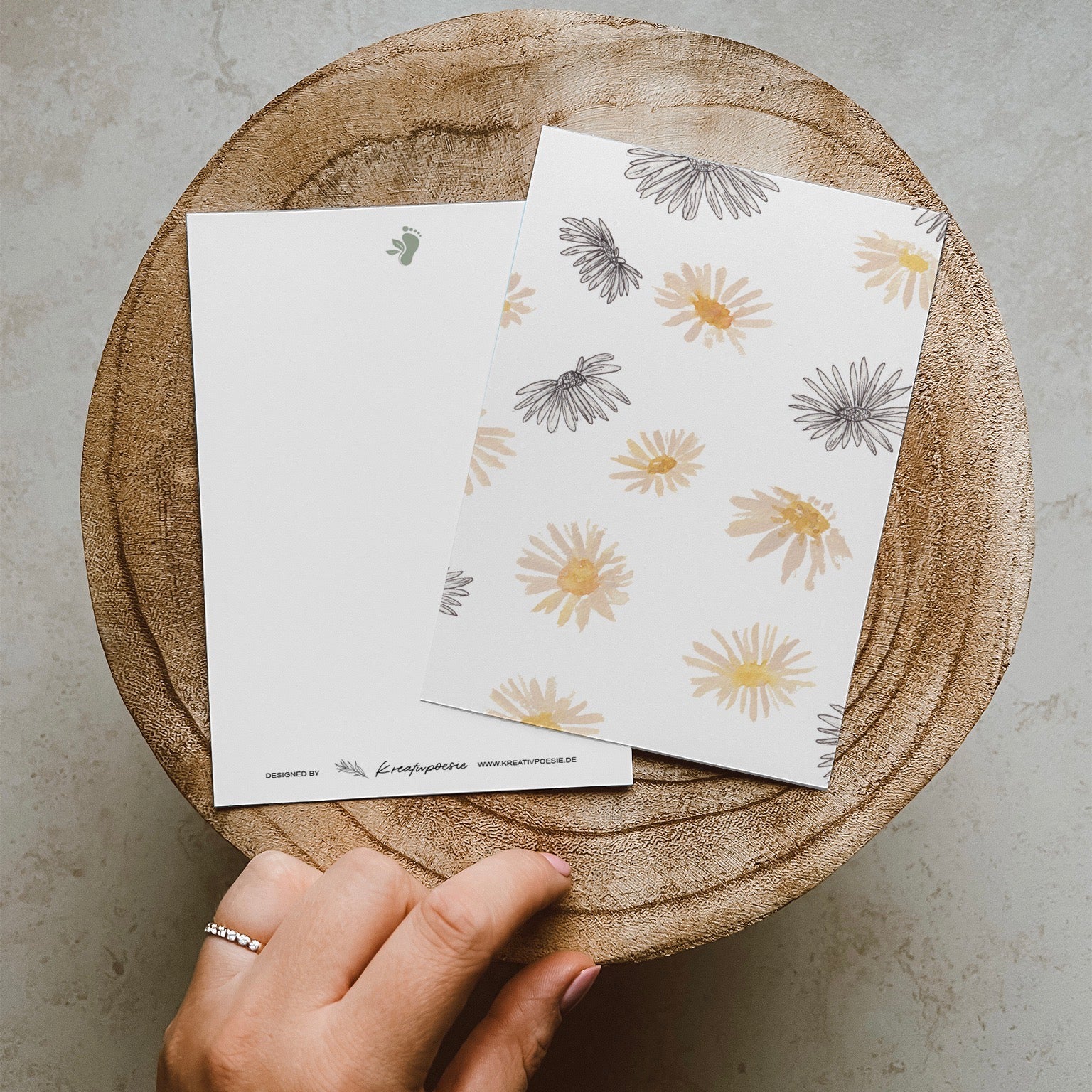 Postkarte DIN A6 im Hochformat. Vielen Gänseblümchen im Line-Art-Stil und Aquarellstil.