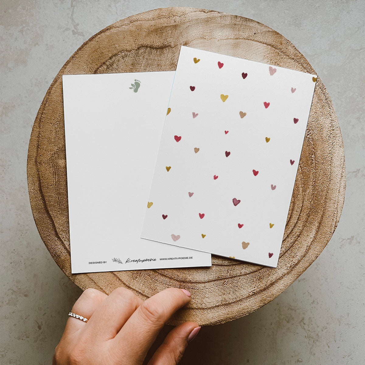 Postkarte DIN A6 im Hochformat. Auf dieser Karte befinden sich verschiedene kleine Herzen in bunten Farben.