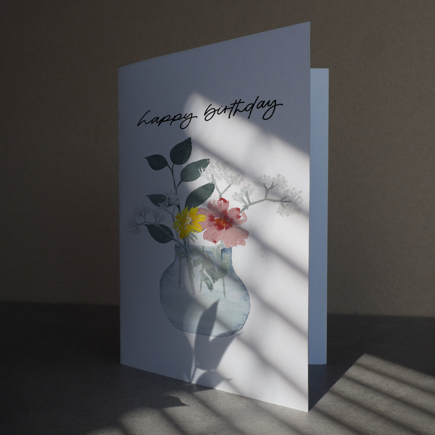 Klappkarte mit buntem Blumenstrauß in durchsichtiger Vase. Lettering: ,,happy birthday''.