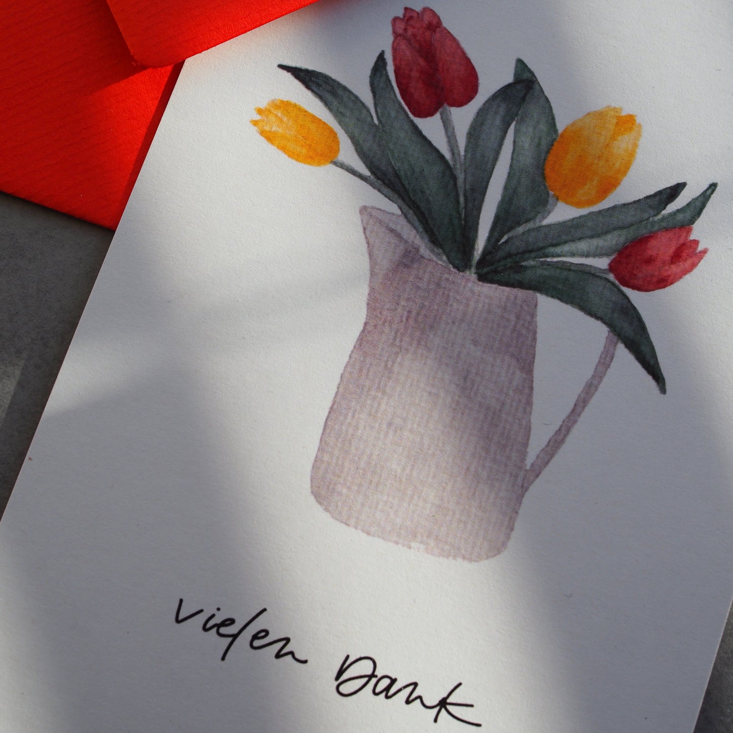 Aquarell-Postkarte DIN A6, Hochformat, Recyclingpapier, gedruckt in Deutschland. Gelbe uns rote Tulpen in einer grau-weißen Kanne. Text: ,,vielen Dank''. Nahansicht.