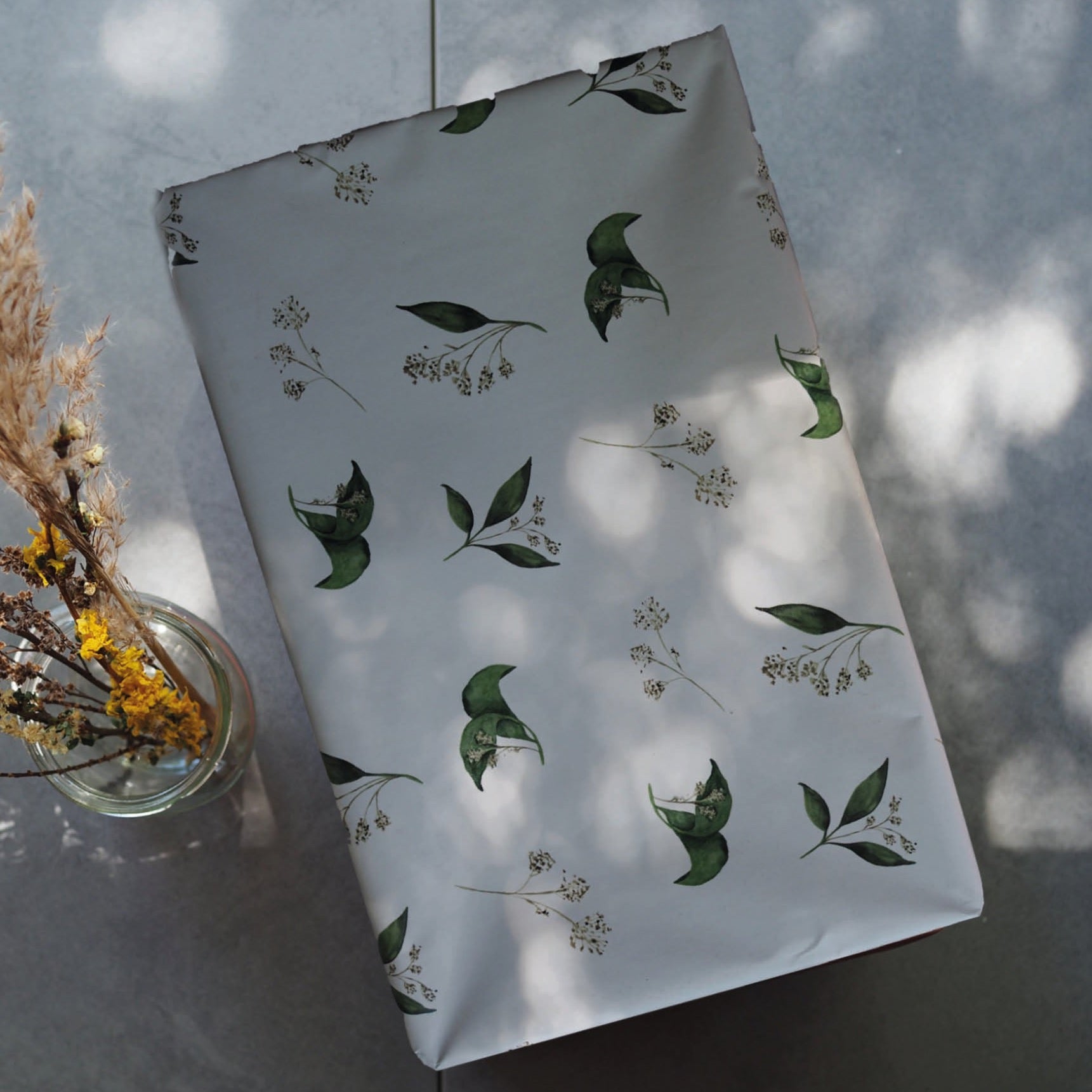 Geschenkpapier-Bogen in der Größe 50x70cm mit grünen Pflanzenelementen.